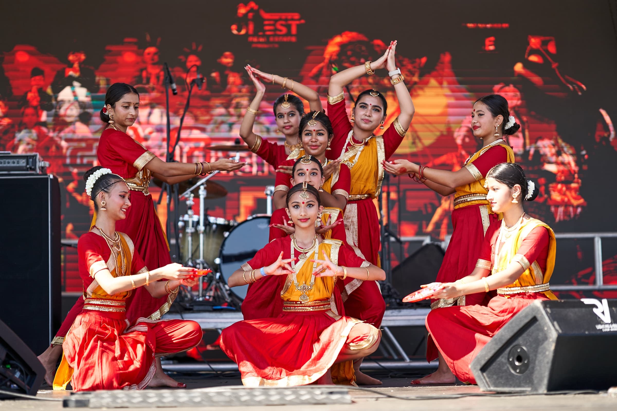 Classical Nepali dancers in red and gold saris on the DT Fest stage