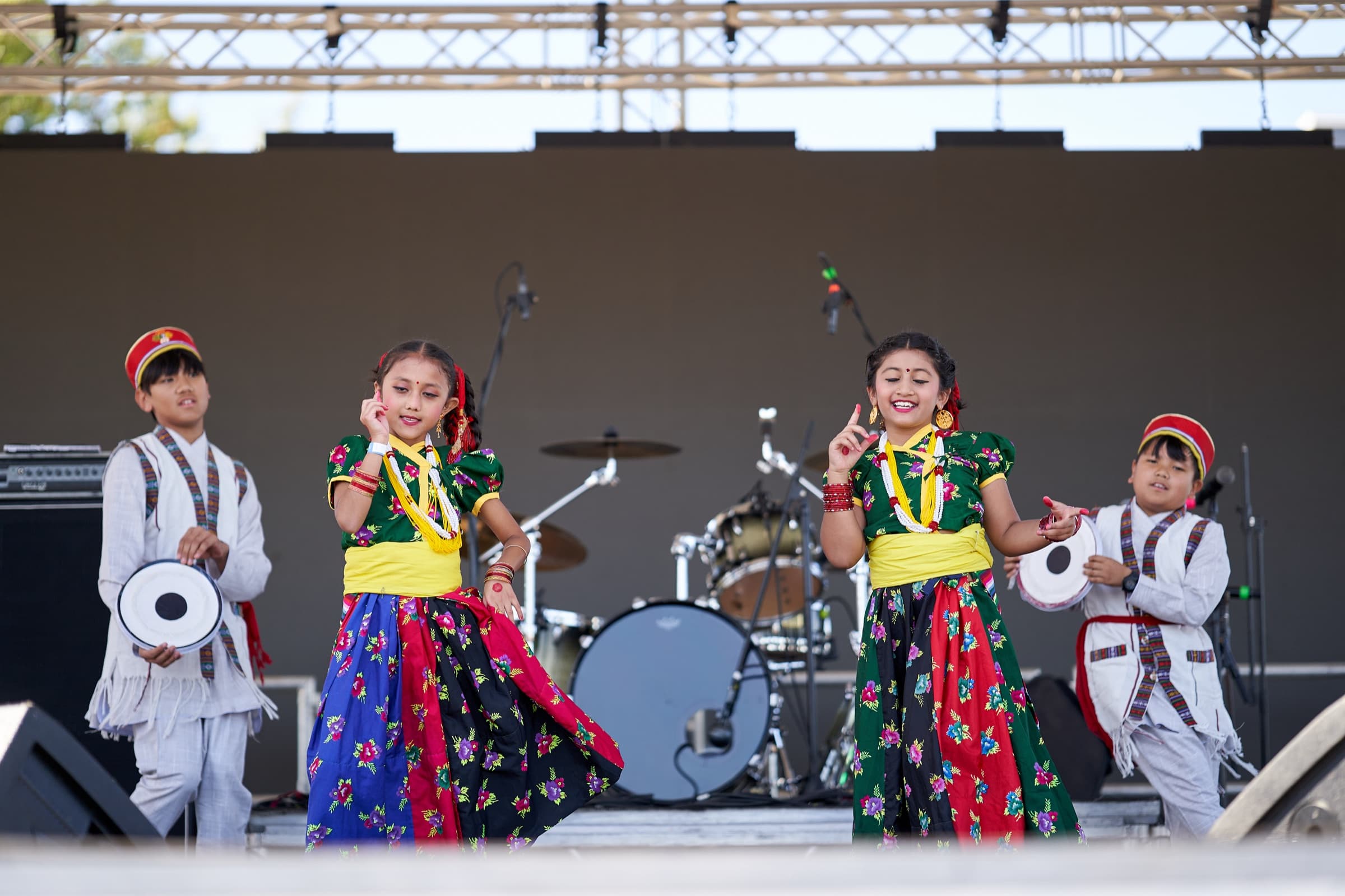 Bharatanatyam performers mid-choreography under festival lights